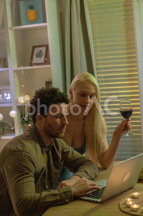 ワインを飲みながら動画チェックする男女 男女,女性,男性の写真素材
