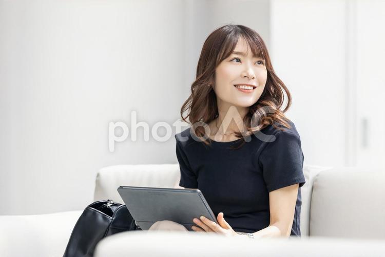 ソファでタブレットを使うビジネスウーマン 女性,ビジネス,タブレットの写真素材