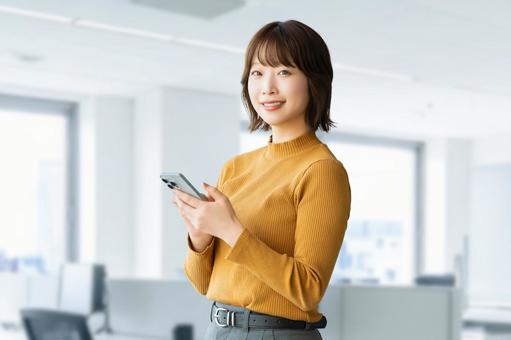 スマホを使う笑顔の女性・ビジネスウーマン 女性,スマホ,スマートフォンの写真素材