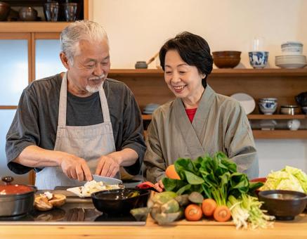 キッチンで会話しながら料理するシニア夫婦 キッチンで会話しながら料理するシニア夫婦の写真