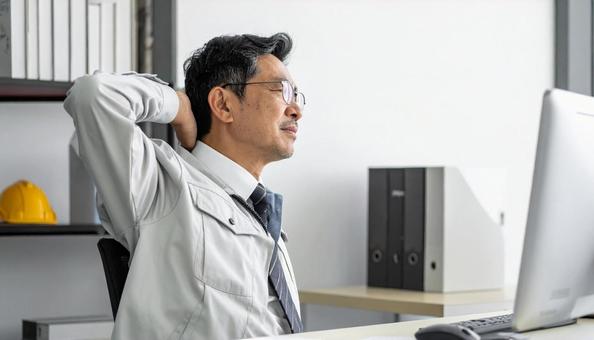仕事の合間に肩を回すミドルのエンジニア 仕事の合間に肩を回すミドルのエンジニアの写真