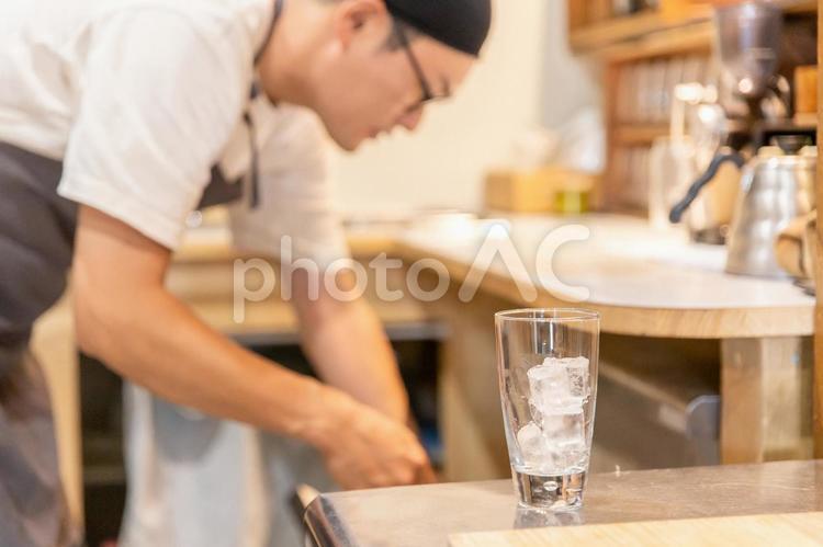 カフェでグラスに氷を入れるスタッフの男性 カフェ,喫茶店,氷の写真素材
