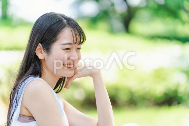 新緑の中で頬杖をつく日本人女性（美容） 女性,横顔,新緑の写真素材