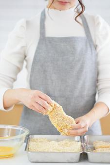 パン粉をつけたとんかつを持つ両手 パン粉をつけたとんかつを持つ両手の写真