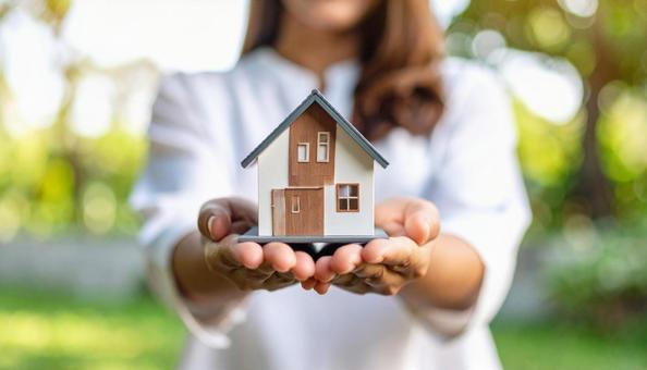 不動産イメージ ミニチュア住宅を差し出す 不動産イメージ ミニチュア住宅を差し出すの写真