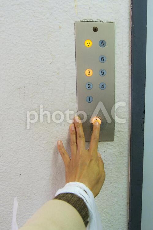 買い物帰りエレベーターのボタンを押す エレベーター,エレベーターのボタン,エレベーターのボタンを押すの写真素材