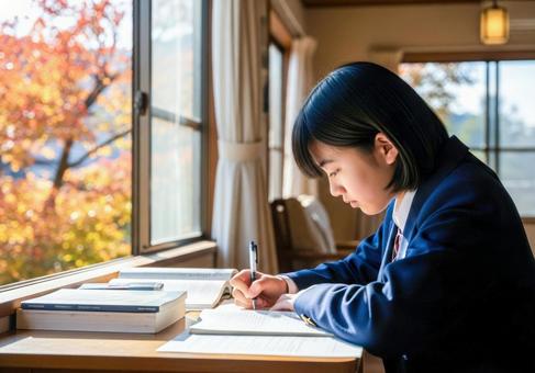 秋の教室で勉強に集中する女子学生の写真