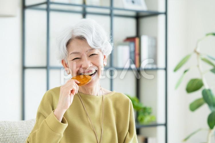 せんべいを食べるシニアの女性 せんべい,煎餅,歯の写真素材