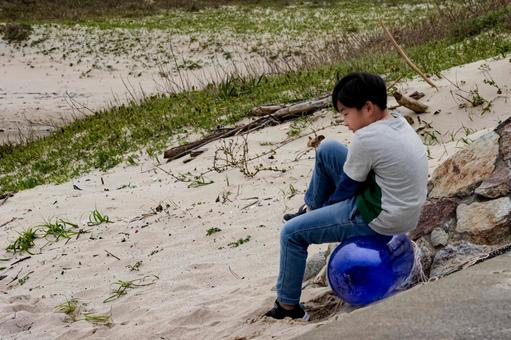 <素材>ビンに座って海を見詰める少年 <素材>ビンに座って海を見詰める少年 子供,男性,人物の写真素材