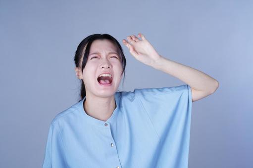 上を仰ぐ青い服の女性 女性,泣き叫ぶ,叫ぶの写真素材