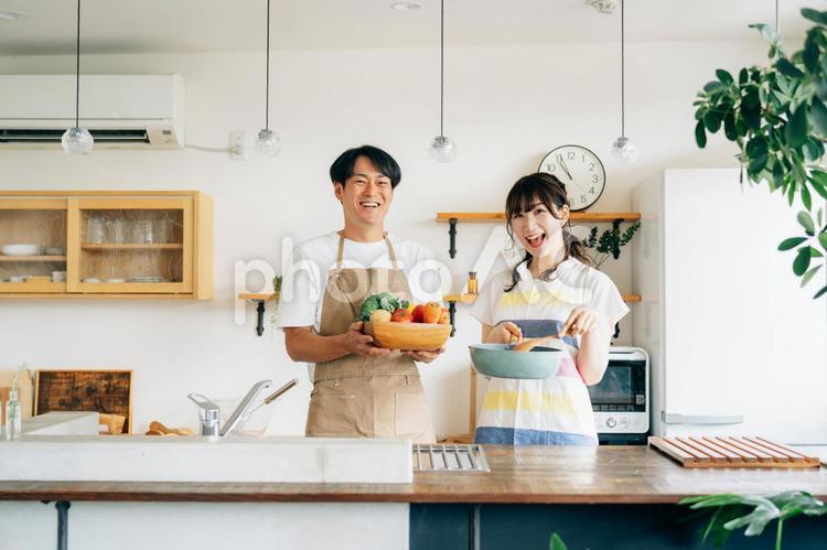 一緒に料理を作る男女（フライパンと野菜） 夫婦,料理,キッチンの写真素材