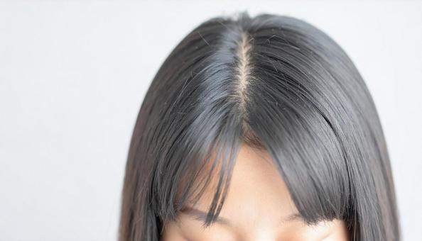 生え際を気にする女性 生え際を気にする女性の写真