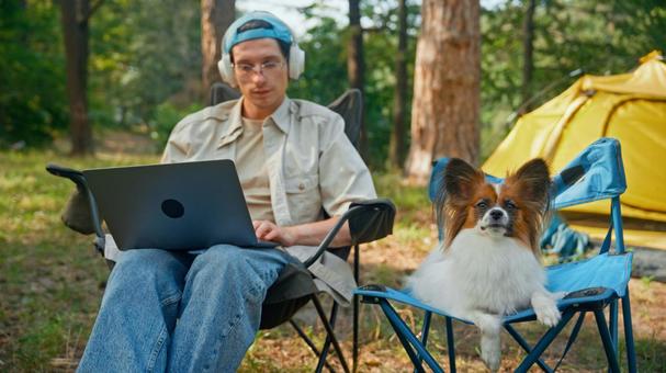 ノートPCで作業をする男性と犬 男性,外国人,犬の写真素材