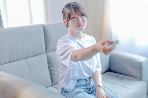 リモコンを操作する女性 リモコンを操作する女性 女性,若い女性,リモコンの写真素材