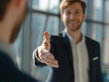 ビジネスシーンで握手を求める外国人男性の写真