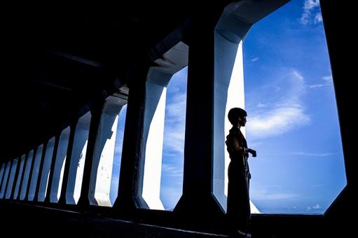 <素材>窓あきトンネルから空を眺める女性 <素材>窓あきトンネルから空を眺める女性の写真