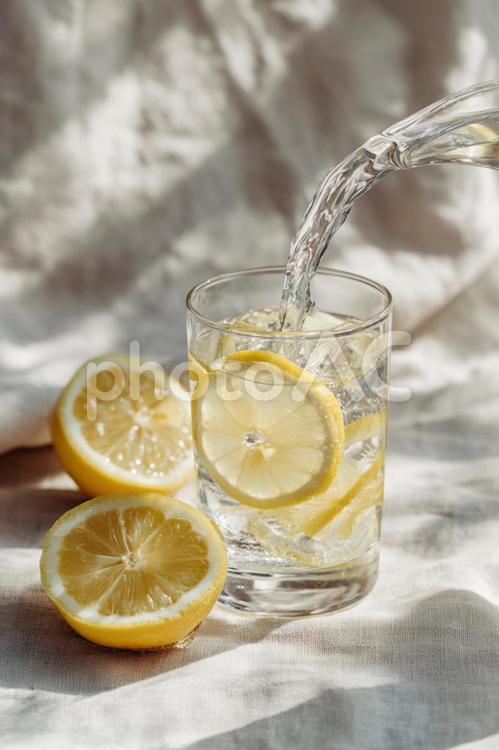 フレッシュなレモンウォーターを注ぐ レモン,水,グラスの写真素材