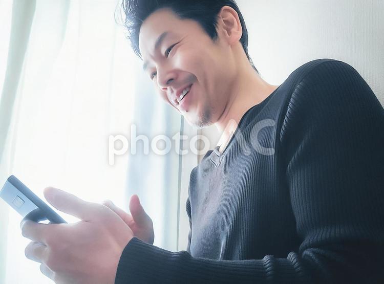 携帯電話を持つ笑顔の中年男性 男性,男,人物の写真素材