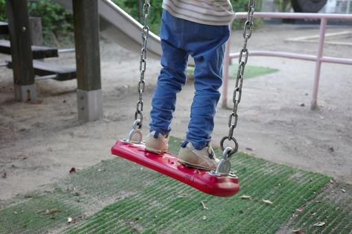 公園でブランコに乗る子どもの後ろ姿 ブランコ,公園,子どもの写真素材