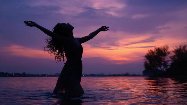 夕焼けに染まる海の女性 夕焼けに染まる海の女性の写真