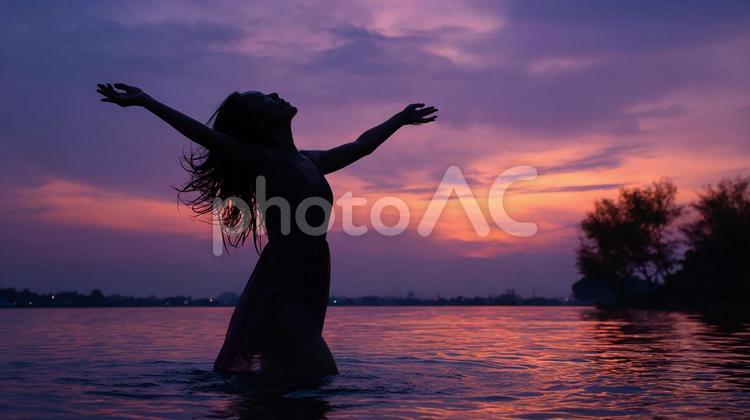 夕焼けに染まる海の女性 女性,シルエット,海の写真素材