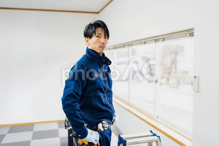 作業服を着て立つ男性電気工事作業員 ビジネス,ビジネスマン,男の写真素材