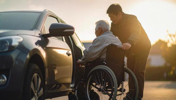 車椅子高齢男性の車の乗車を介助する男性 車椅子高齢男性の車の乗車を介助する男性の写真