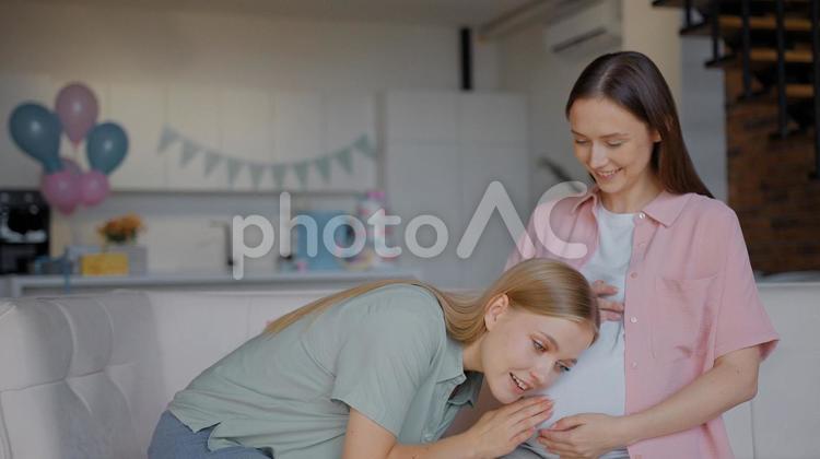 妊婦と話して耳をつける女性 女性,人物,座るの写真素材