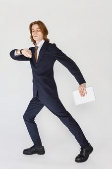 歩くポーズで腕時計を見るスーツの男性 男性,外国人,欧米人の写真素材