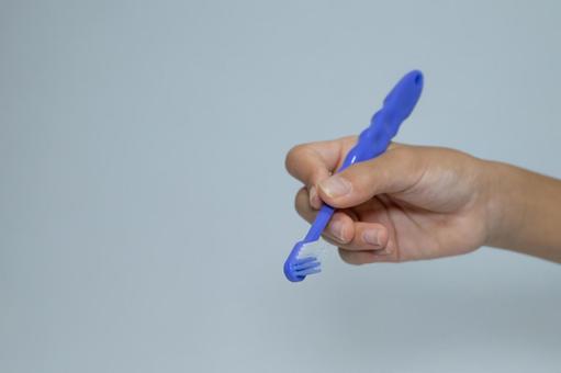 青い歯ブラシを持つ手 歯ブラシ,青,歯磨きの写真素材