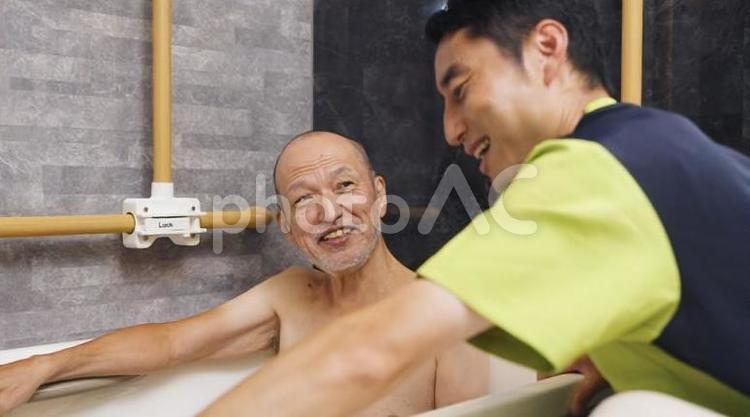 入浴介助を受けるアジア人高齢者 高齢者,一般浴槽,入浴の写真素材