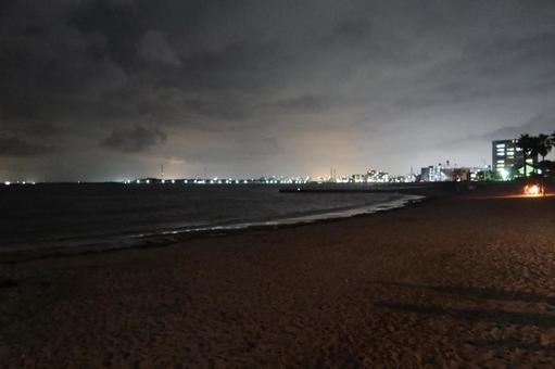 夜の砂浜から見た町の明かり 夜の砂浜から見た町の明かりの写真