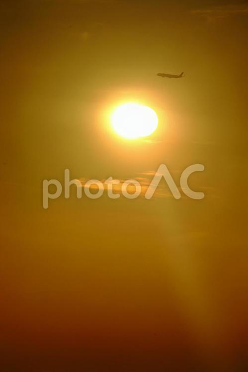 夕日の上を飛ぶ飛行機 飛行機,夕日,シルエットの写真素材