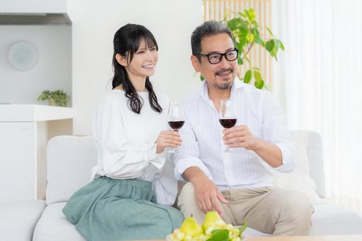 リビングでワインを飲むミドルの夫婦 リビングでワインを飲むミドルの夫婦 夫婦,家族,乾杯の写真素材