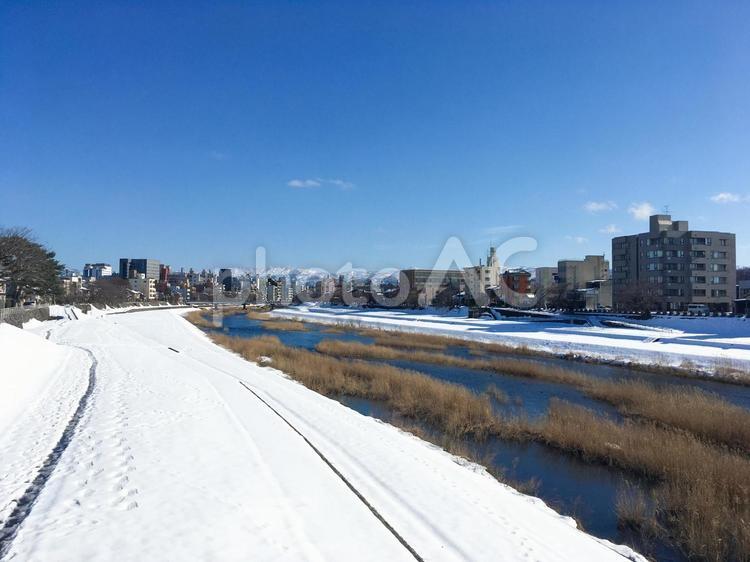 雪が積もった川沿いの景色　青空　冬の犀川 冬景色,雪,積雪の写真素材