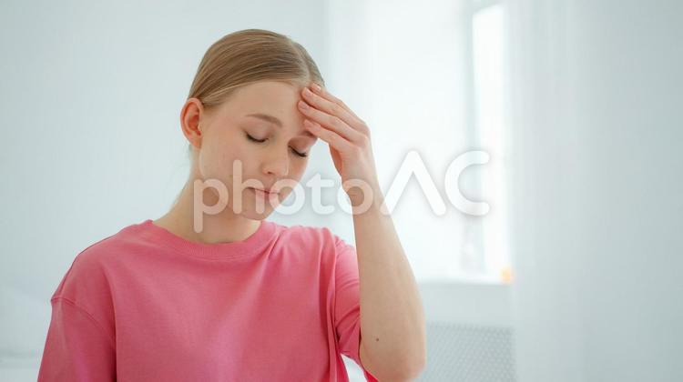 左手で額を押さえる女性 女性,頭痛,悩むの写真素材