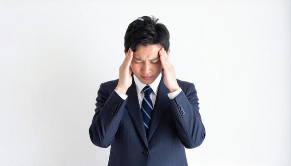 ストレスで顔をおおう日本人ビジネスマン ストレスで顔をおおう日本人ビジネスマンの写真