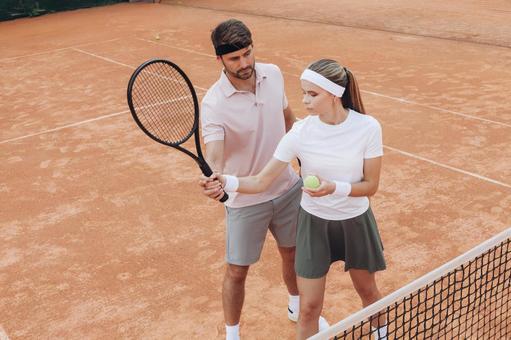 白いシャツの女性にフォームを教える男性 男女,外国人,テニスの写真素材
