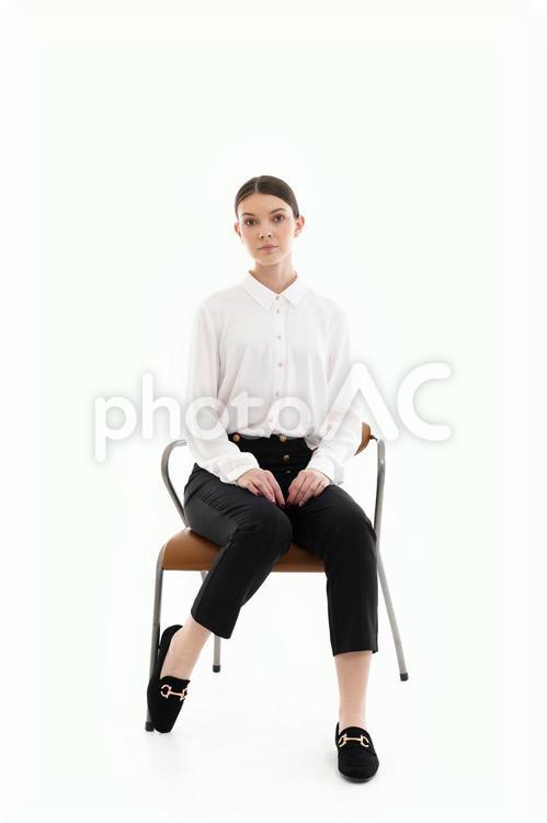 真顔で座る白シャツの女性 女性,座る,椅子の写真素材