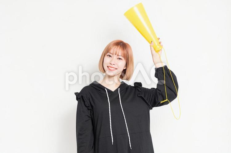 白背景の前で応援のジェスチャーをする若い女性 応援,声援,女性の写真素材