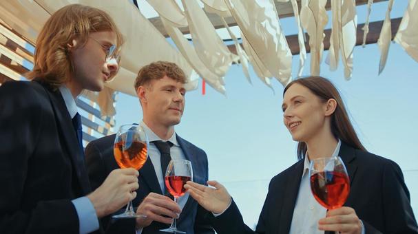 ワイングラスを持ち女性の話を聞く男性2人 男女,ワイングラス,ワインの写真素材