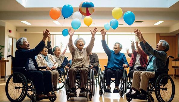 椅子に座り楽しそうに風船バレーをする患者 椅子に座り楽しそうに風船バレーをする患者の写真