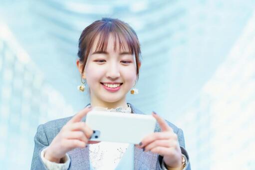 スマートフォンの画面を見る若い女性  スマホ,操作,アプリの写真素材