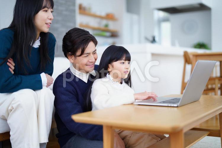 パソコンを見る女の子と家族 家族,女の子,女性の写真素材