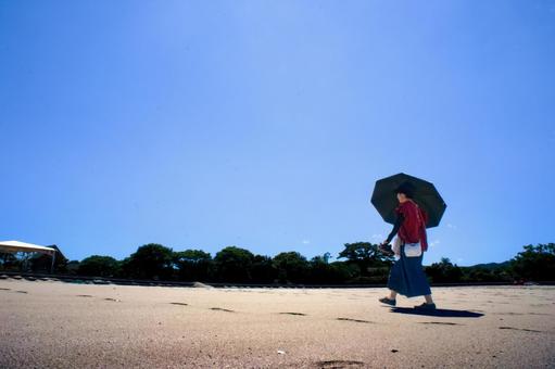<素材>夏の海水浴場で遊ぶ日傘の女性 <素材>夏の海水浴場で遊ぶ日傘の女性 女性,人物,夏の写真素材