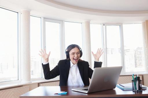 両手を広げ喜ぶ女性 女性,外国人,ノートパソコンの写真素材