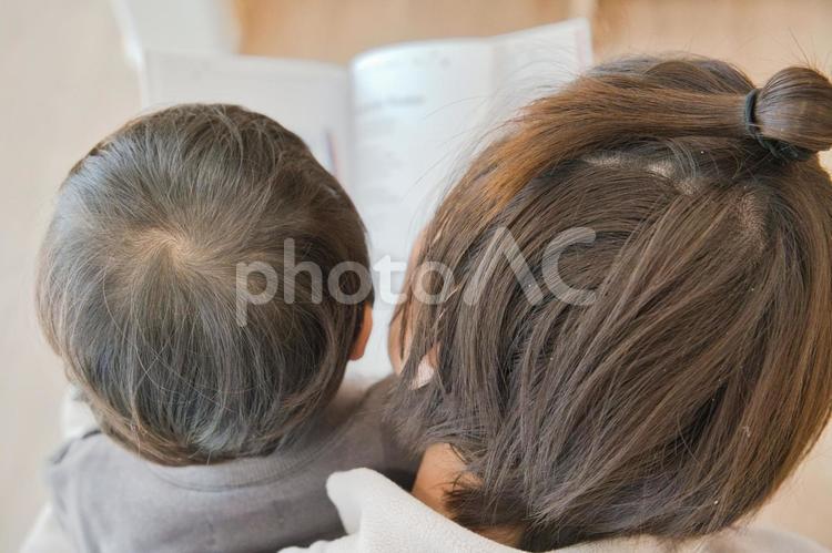 子供と一緒に読書をする母親 本,読書,手元の写真素材