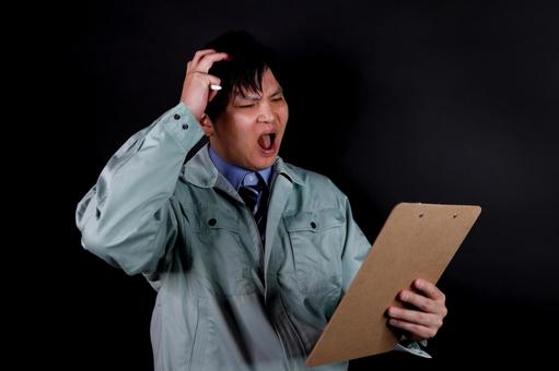 書類に困惑する作業員 作業員,男性,困惑の写真素材
