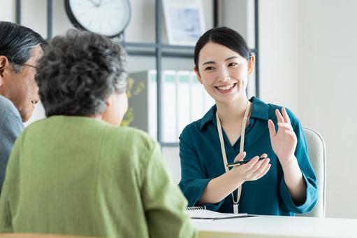 シニアの夫婦に提案するプランナー シニアの夫婦に提案するプランナー 営業,シニア,笑顔の写真素材
