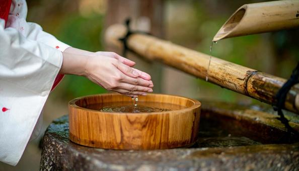 神社の手水舎で手を清める着物女性の手もと 神社の手水舎で手を清める着物女性の手もとの写真